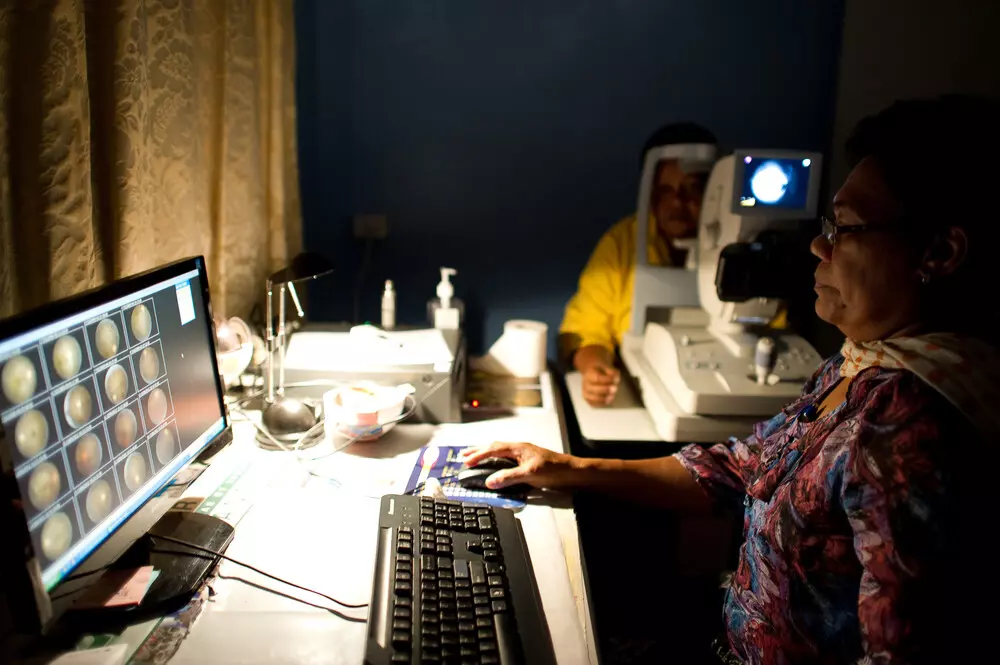 A nurse viewing scans of a patients eye