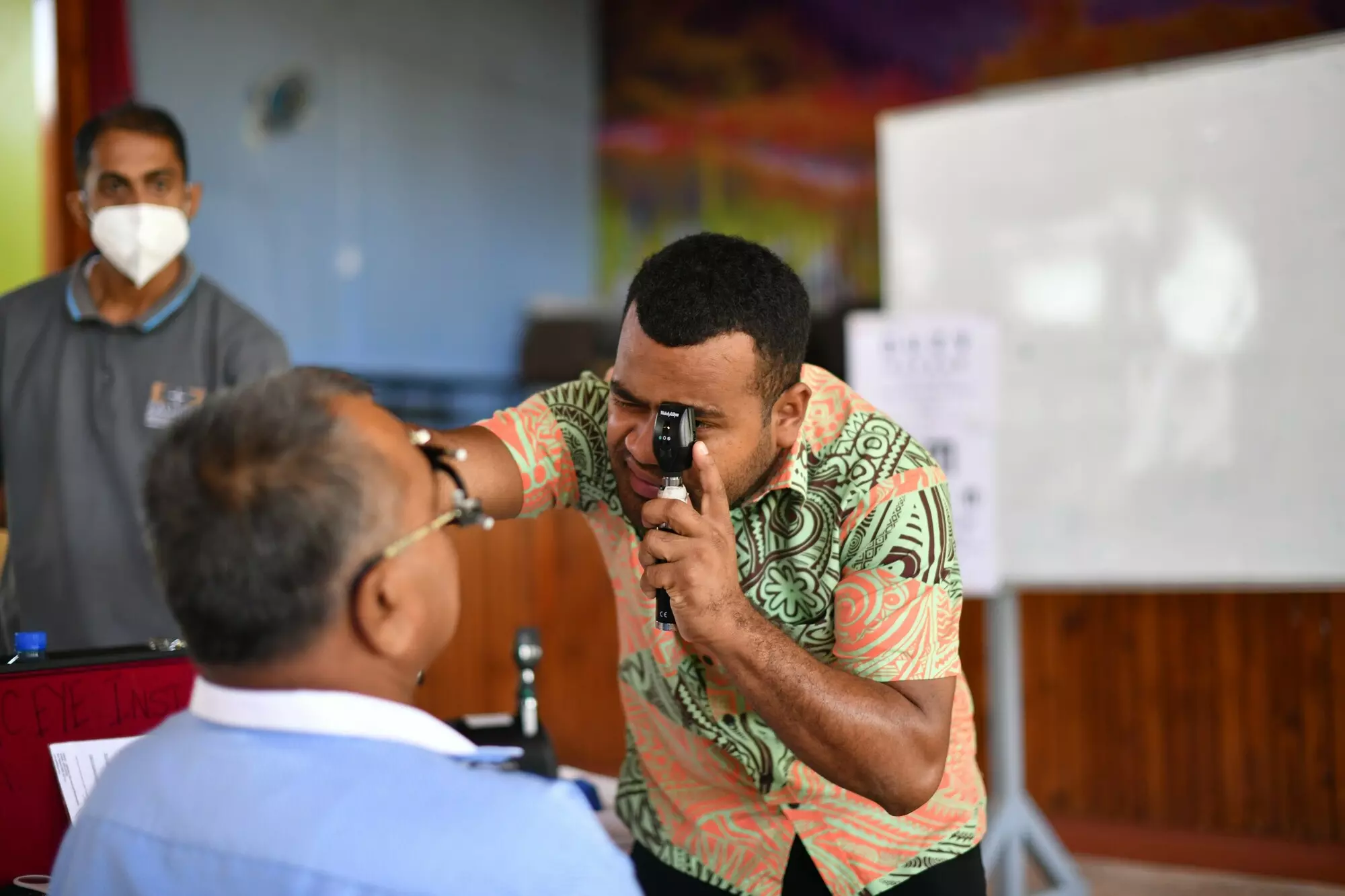 Trainee doctor examining a patients eye