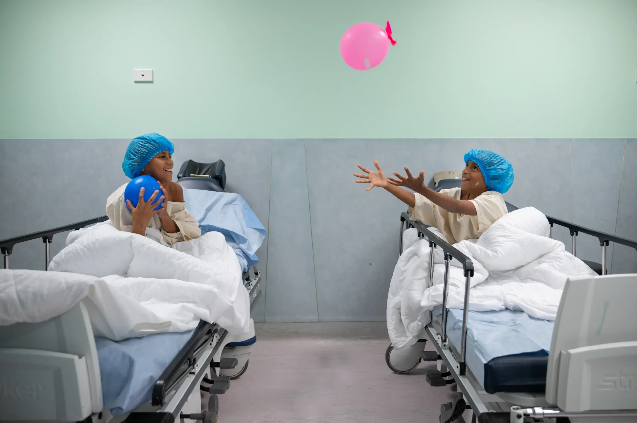 Meli and another child playing with a balloon while waiting for surgery