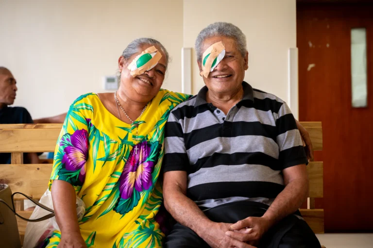 Setefania and Penetito in the waiting room wearing eye bandages