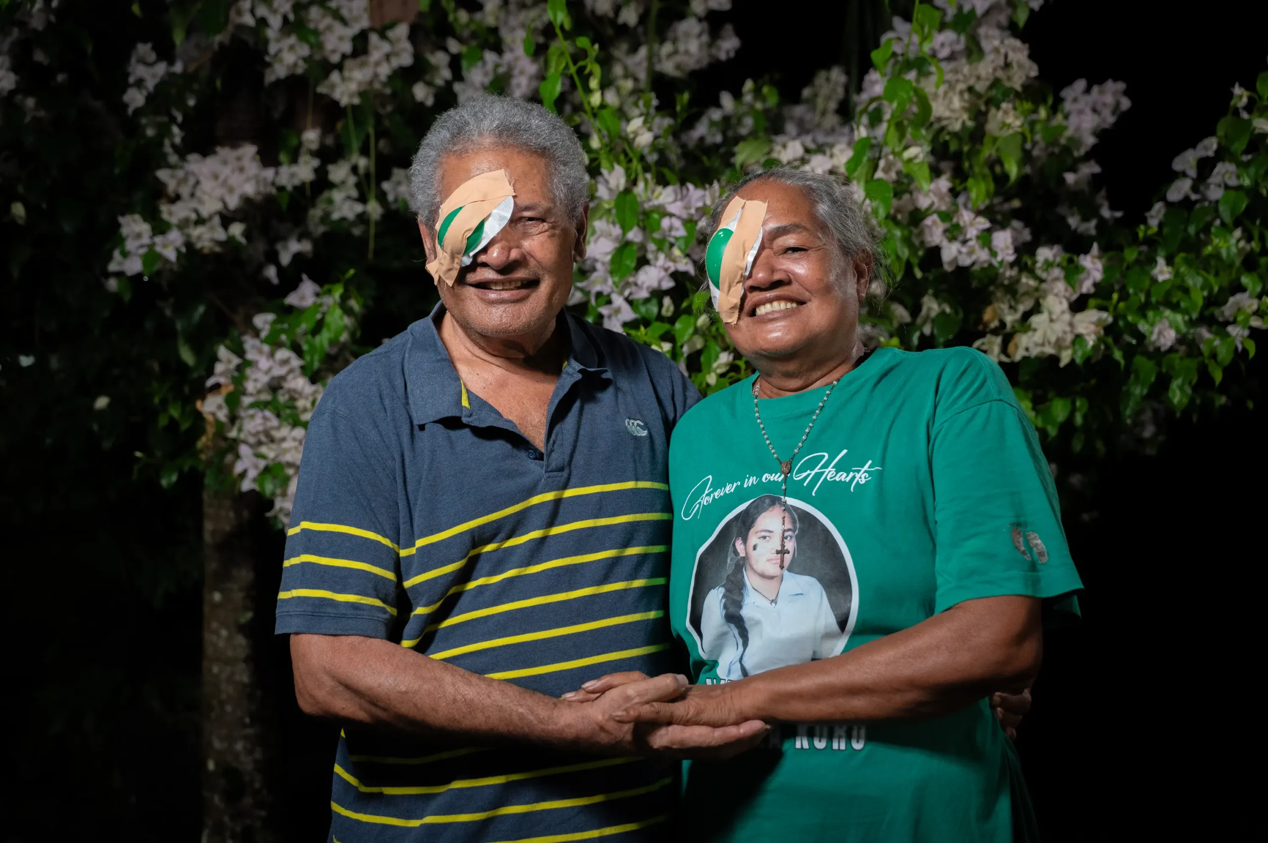 Penetito and Setefania wearing their eye bandages and holding hands